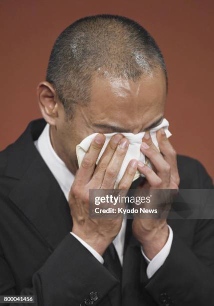 Japanese kabuki star Ichikawa Ebizo wipes away tears during a press conference in Tokyo on June 23 after his wife Mao Kobayashi, a 34-year-old...