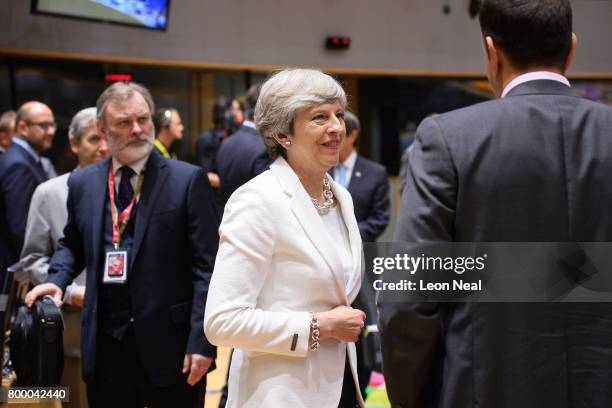 British Prime Minister Theresa May talks with other leaders as the UK Ambassador to the EU Tim Barrow looks on, ahead of a roundtabel meeting at the...