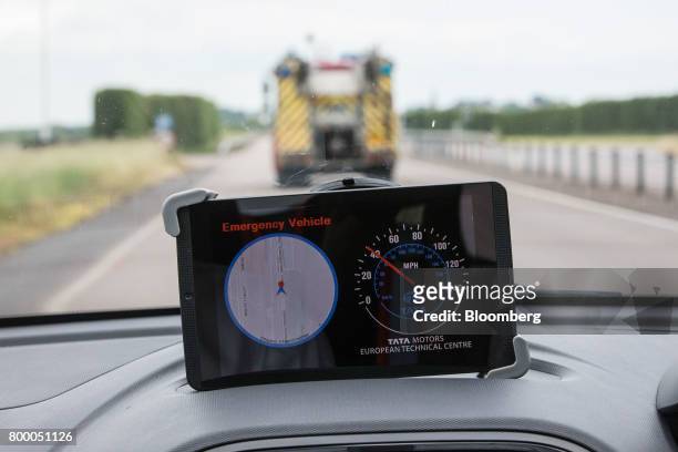 Tablet displays an Emergency Vehicle Warning using connected vehicle technology in a Tiago automobile, manufactured by Tata Motors Ltd., as a fire...