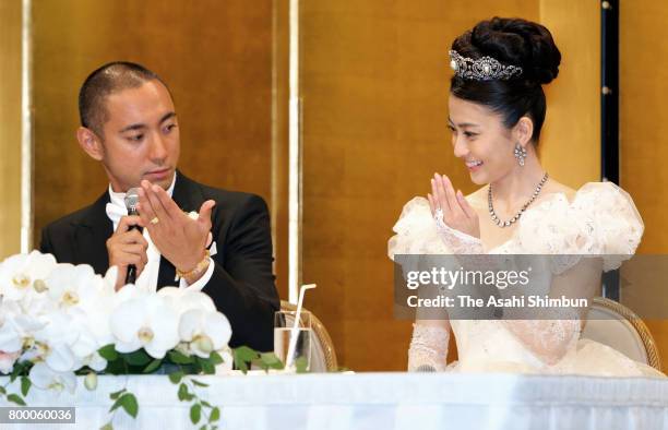 Kabuki actor Ebizo Ichikawa and former TV anchor Mao Kobayashi show their wedding bands at the press conference after their wedding on July 29, 2010...
