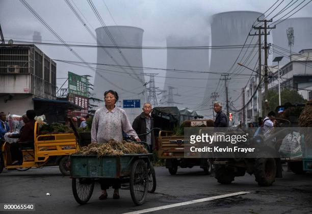 Chinese street vendors sell vegetables at a local market outside a state owned Coal fired power plant near the site of a large floating solar farm...