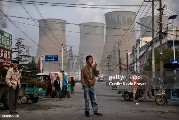 Chinese street vendors and customers gather at a local market outside a state owned Coal fired power plant near the site of a large floating solar...