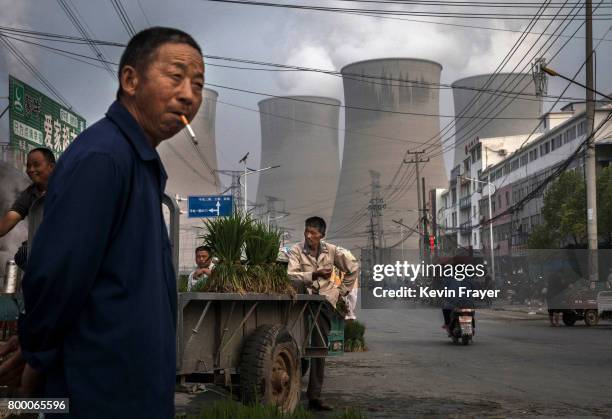 Chinese street vendors sell vegetables at a local market outside a state owned Coal fired power plant near the site of a large floating solar farm...