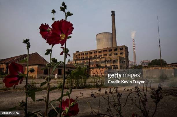 Smokestack from a coal fired power plant is seen next to an abandoned former paper factory near the site of a large floating solar farm project under...