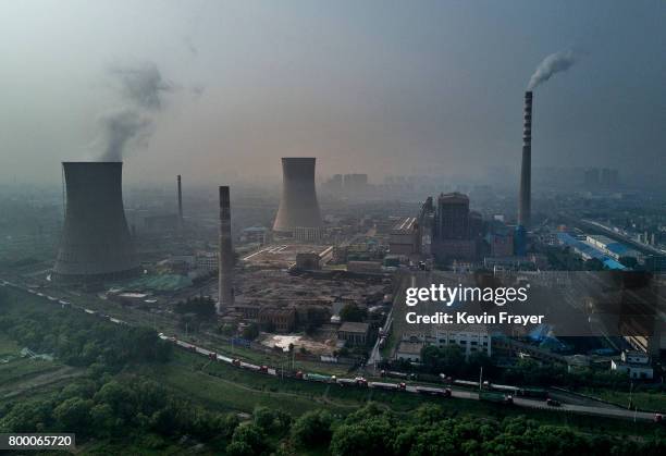 Chinese state owned coal fired power plant is seen near a large floating solar farm project under construction by the Sungrow Power Supply Company on...