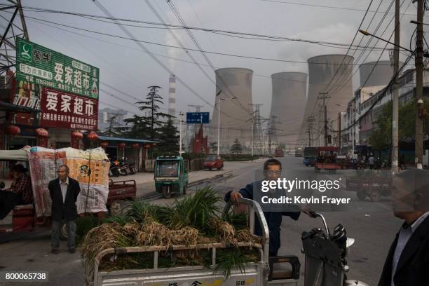 Chinese street vendors wait for customers at a local market outside a state owned coal fired power plant near the site of a large floating solar farm...