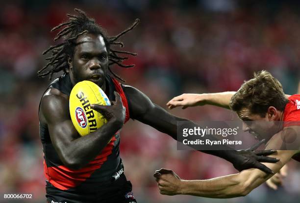 Anthony McDonald-Tipungwuti of the Bombers fends off Jake Lloyd of the Swans during the round 14 AFL match between the Sydney Swans and the Essendon...