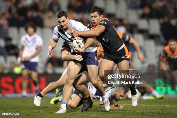 Morgan Boyle of the Titans is tackled during the round 16 NRL match between the Wests Tigers and the Gold Coast Titans at Campbelltown Sports Stadium...