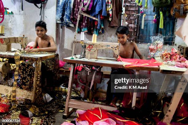 Young boy sews a cloth in a local garment shop in Dhaka, Bangladesh. World Day Against Child Labor was observed on 12 June across the world to raise...