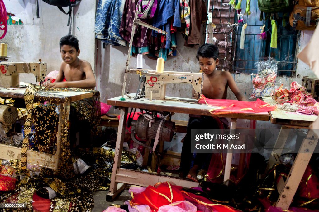 Young boy sews a cloth in a local garment shop in Dhaka,...