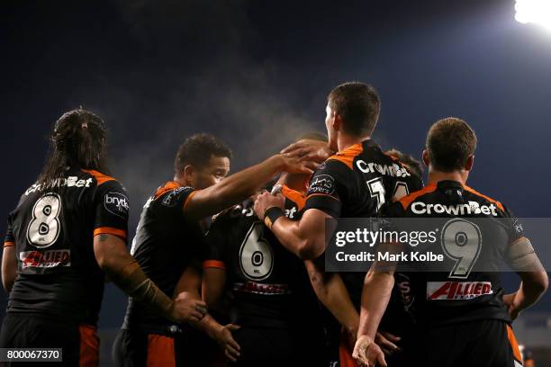 The Tigers players celebrate David Nofoaluma scoring a try during the round 16 NRL match between the Wests Tigers and the Gold Coast Titans at...