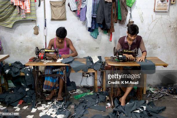 Young boys stitch a cloth in a local garment shop in Dhaka, Bangladesh. World Day Against Child Labor was observed on 12 June across the world to...