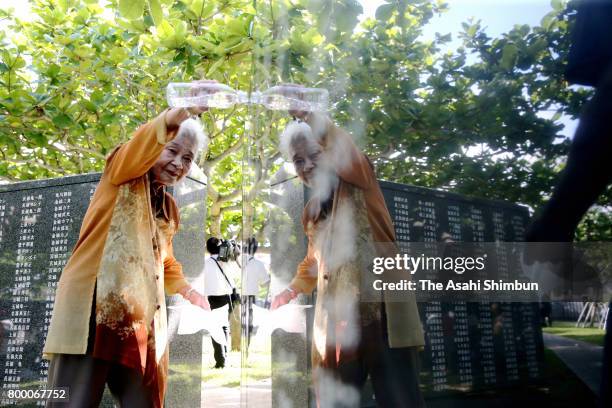 Woman cleans the names of her mother and other relatives engraved on the Cornerstone of Peace at the Peace Memorial Park on the 72nd anniversary of...