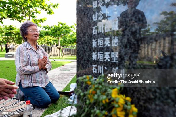 Woman prays in front of the Cornerstone of Peace where the names of their bereaved family members and relatives engraved at the Peace Memorial Park...