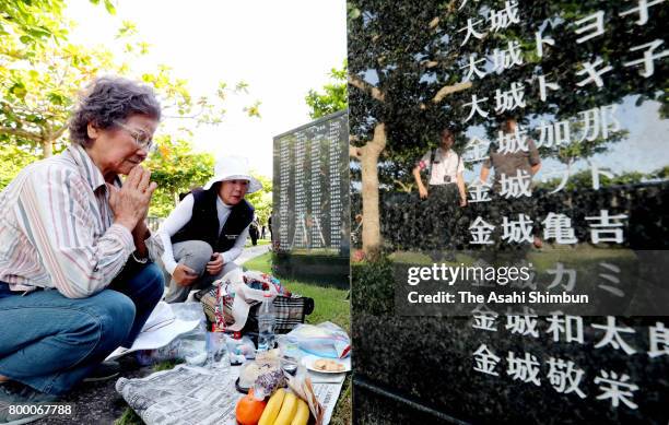 People pray in front of the Cornerstone of Peace where the names of their bereaved family members and relatives engraved at the Peace Memorial Park...