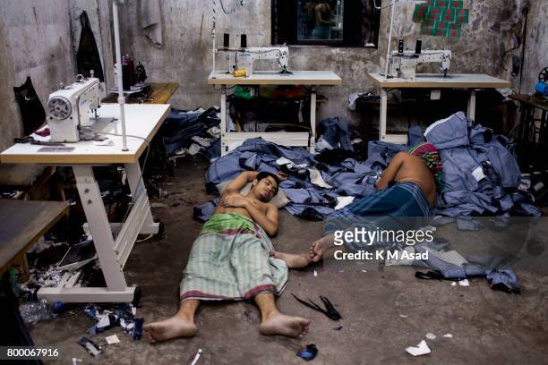Garments labourers sleep over the denim jeans in a local denim garments shop in Dhaka.