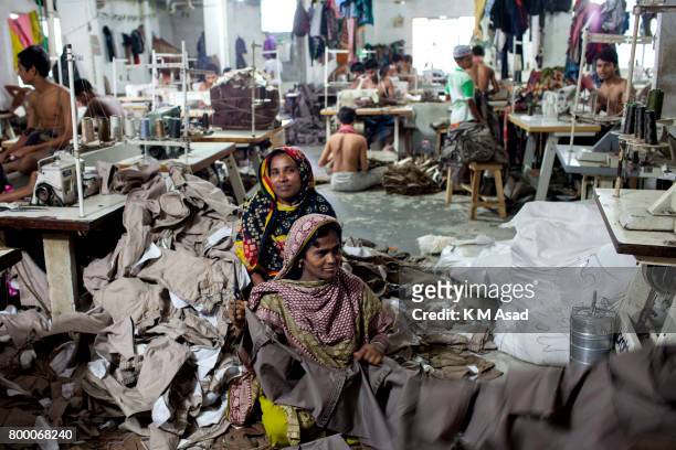 Women sews a cloth in a local garment shop in Dhaka, Bangladesh. World Day Against Child Labor was observed on 12 June across the world to raise...