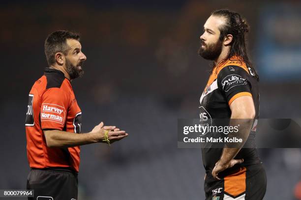 Referee Gavin Badger speaks to Aaron Woods of the Tigers during the round 16 NRL match between the Wests Tigers and the Gold Coast Titans at...