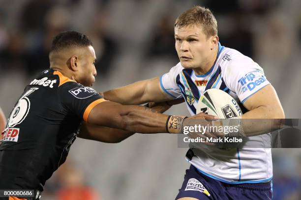 Tu'imoala Lolohea of the Tigers tackles Dale Copley of the Titans during the round 16 NRL match between the Wests Tigers and the Gold Coast Titans at...