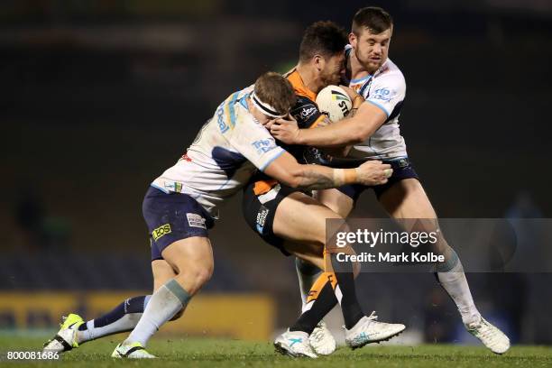 Michael Chee-Kam of the Tigers is tackled during the round 16 NRL match between the Wests Tigers and the Gold Coast Titans at Campbelltown Sports...