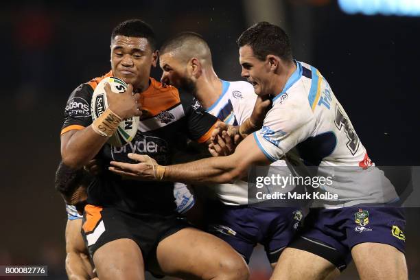 Moses Suli of the Tigers is tackled during the round 16 NRL match between the Wests Tigers and the Gold Coast Titans at Campbelltown Sports Stadium...