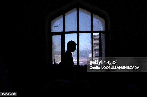 An Afghan Muslim offers his prayers on the last Friday of the holy month of Ramadan ahead of the Muslim festival of Eid al-Fitr, at a mosque in...