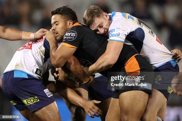 Esan Marsters of the Tigers is tackled during the round 16 NRL match between the Wests Tigers and the Gold Coast Titans at Campbelltown Sports...