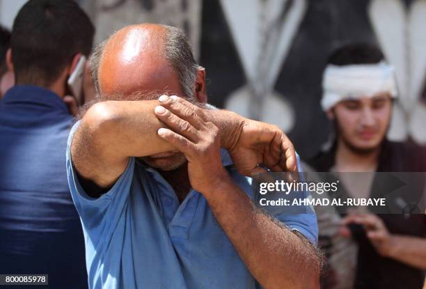 An Iraqi civilian, who was injured in a suicide attack as people were escaping the Old City of Mosul, cries outside a make-shift hospital on June 23,...