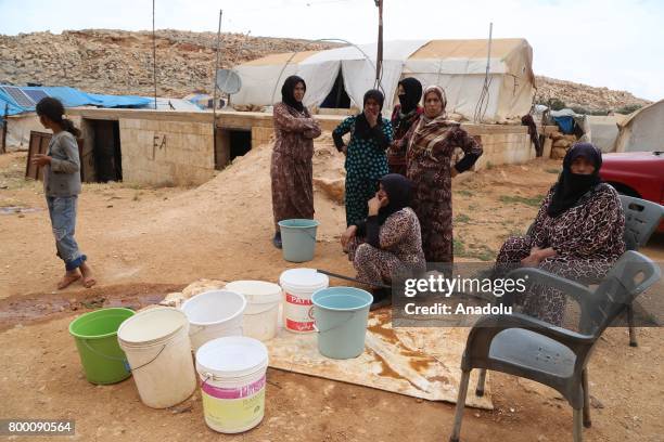 Syrian women fill their buckets with water, during Muslim's holy month of Ramadan in Idlib, Syria on June 23, 2017. Ahead of Eid al Fitr, Syrian...