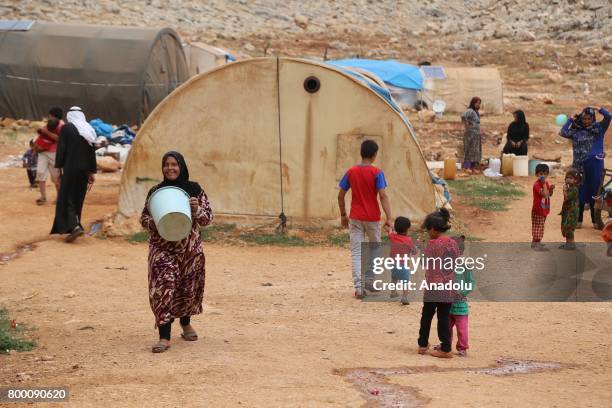 Syrian woman carries a bucket, during Muslim's holy month of Ramadan in Idlib, Syria on June 23, 2017. Ahead of Eid al Fitr, Syrian people who fled...