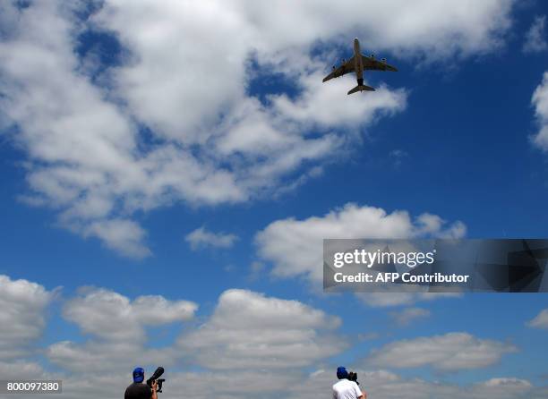 Plane spotters take pictures and videos of an Airbus A380 as it takes off during the International Paris Air Show in Le Bourget near Paris on June...