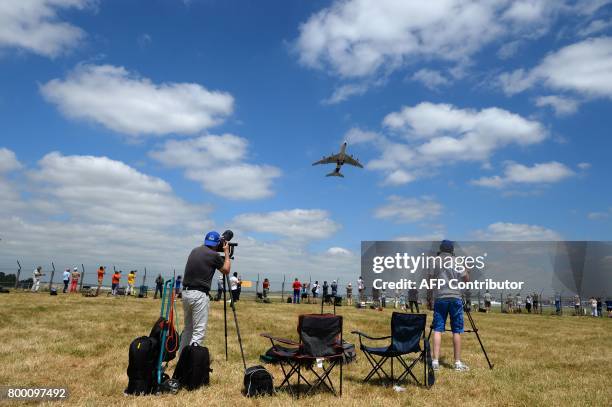 Plane spotters take pictures and videos of an Airbus A380 as it takes off during the International Paris Air Show in Le Bourget near Paris on June...