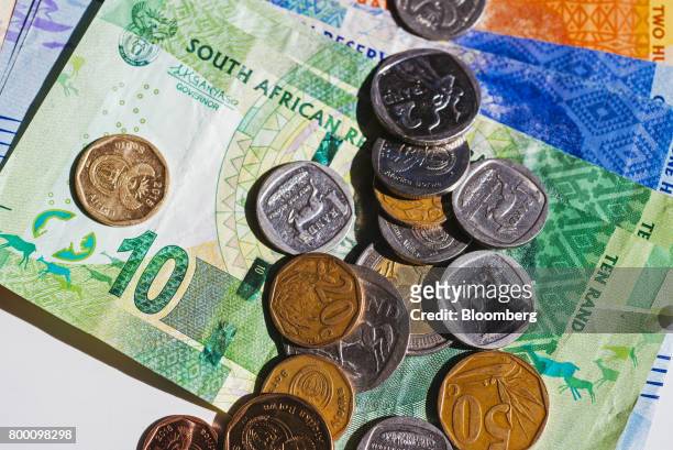 Collection of mixed denomination South African rand coins and banknotes sit in an arranged photo in Johannesburg, South Africa, on Thursday, June 22,...