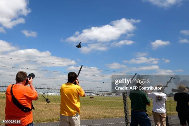 Plane spotters take pictures and videos of a Dassault Aviation Rafale jet fighter as it takes off during the International Paris Air Show in Le...