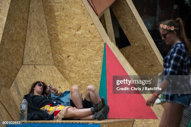 Man and woman sleep on a structure at the Greenpeace area at Glastonbury Festival Site o on June 23, 2017 near Glastonbury, England. Glastonbury...