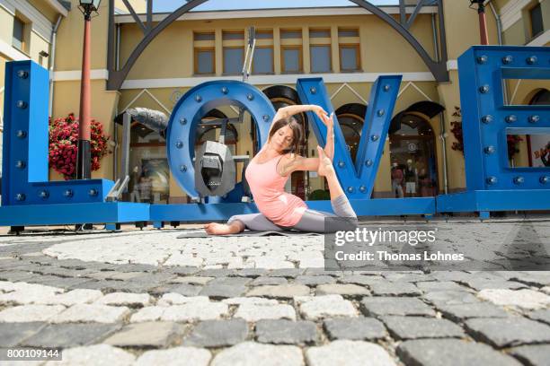 Jana Pallaske poses with Yoga next to the skulptures of the artist Il-Jin Atem Chio at Wertheim Village on June 20, 2017 in Wertheim, Germany. The...