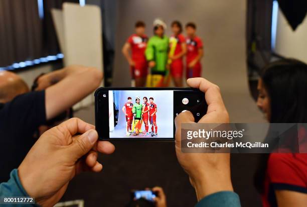 Team official takes a smartphone photograph during a player portrait photo session for FINTRO Hockey World League on June 23, 2017 in Brussels,...