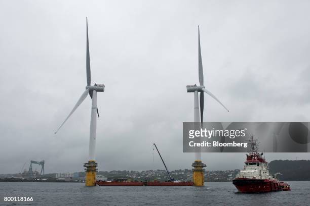 Barges position offshore floating wind turbines during assembly in the Hywind pilot park, operated by Statoil ASA, in Stord, Norway, on Friday, June...
