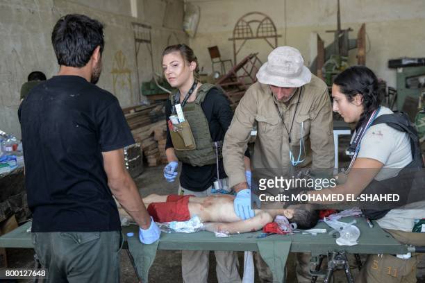 An Iraqi boy, who suffered injuries following a suicide attack as he was escaping the Old City of Mosul, receives treatment at a field hospital on...