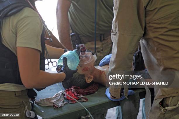 An Iraqi boy, who suffered injuries following a suicide attack as he was escaping the Old City of Mosul, receives treatment at a field hospital on...