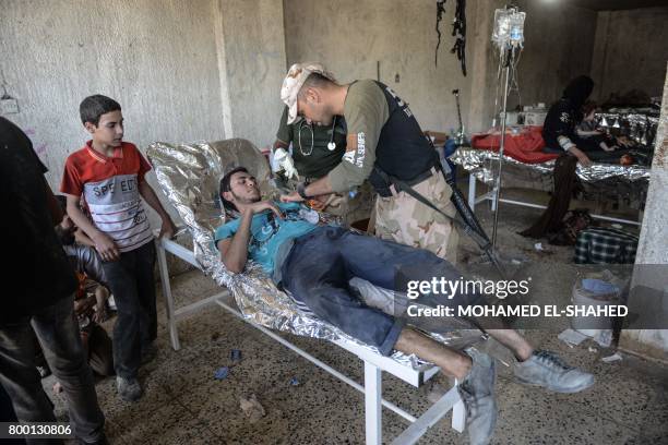 An Iraqi man, who suffered injuries following a suicide attack as he was escaping the Old City of Mosul, receives treatment at a field hospital on...