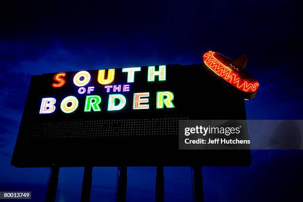 The glowing neon of a South of the Border sign calls out to those driving through the night along Highway 95 at South of the Border on July 21, 2006...