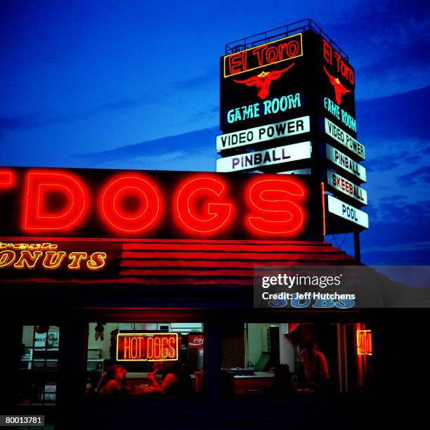 Under a neon sign restaurant goers much on hot dogs at South of the Border on July 21, 2006 in Dillon, South Carolina. Nearly unrivaled as a tourist...