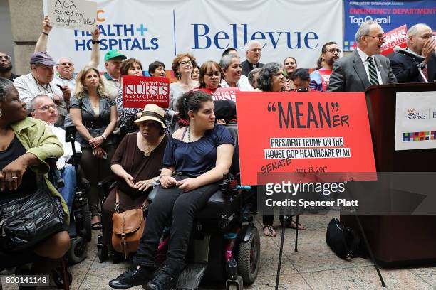 Doctors, nurses, patients and activists listen as Senate Minority Leader Chuck Schumer speaks at Bellevue Hospital a day after the Republicans...