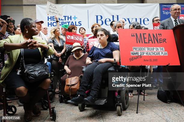 Doctors, nurses, patients and activists listen as Senate Minority Leader Chuck Schumer speaks at Bellevue Hospital a day after the Republicans...