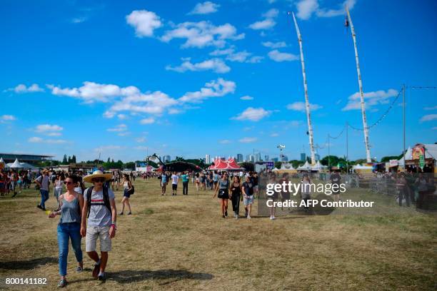 People attend the Solidays music festival on June 23, 2017 at the Longchamp Hippodrome in Paris. / AFP PHOTO / Martin BUREAU