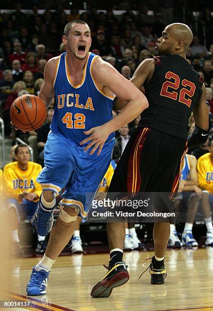 Kevin Love of the UCLA Bruins dribble drives baseline against Taj Gibson of the USC Trojans in the second half during their Pac-10 Conference game at...