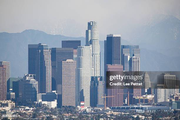 a view of down town los angeles. shot with 600mm lens. san gabriel mountains are slightly visible due to fog/haze/smog. slight heat haze visible on buildings.  - slightly visible stock pictures, royalty-free photos & images