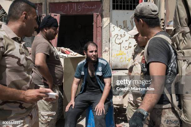 An Iraqi man who has fled the Islamic State controlled Old City of west Mosul where heavy fighting continues is questioned and searched, believed to...