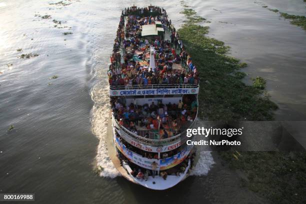 Bangladeshi travelers ride on an over crowed ferry as they go home to celebrate Eid-al-Fitr festival in Dhaka, Bangladesh on June 23, 2017. Muslims...